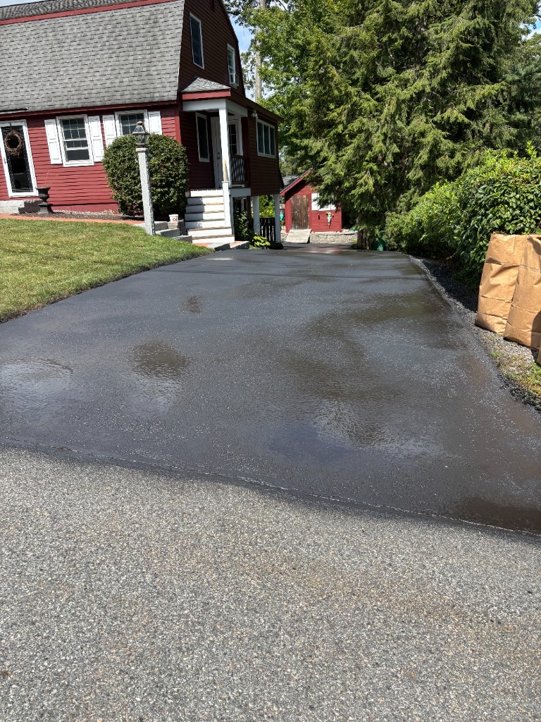 Long driveway sealcoating job with smooth asphalt finish